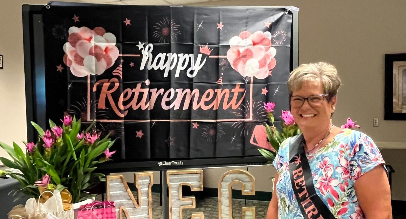 Linda Lever poses next to her table of gifts from coworkers. 